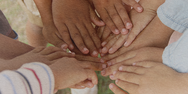 A imagem sobre o projeto da QCP com o Instituto Votorantim remete a união e proteção de crianças e adolescentes a partir de diversas mãos infantis conectadas.